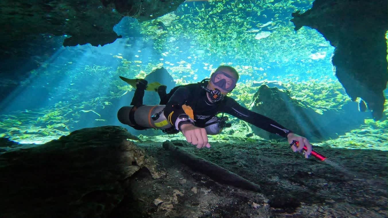 Diver in the light rays of Cueva del Agua