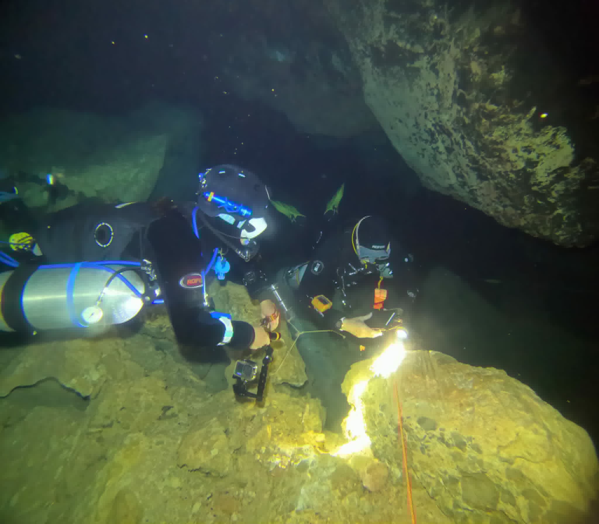 Two cave divers with lights